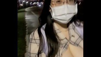 Pretty Asian girl shows off her big boobs while walking along the river