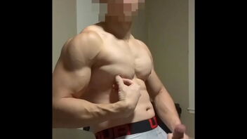 A young Asian man showing off his muscles and masturbating.